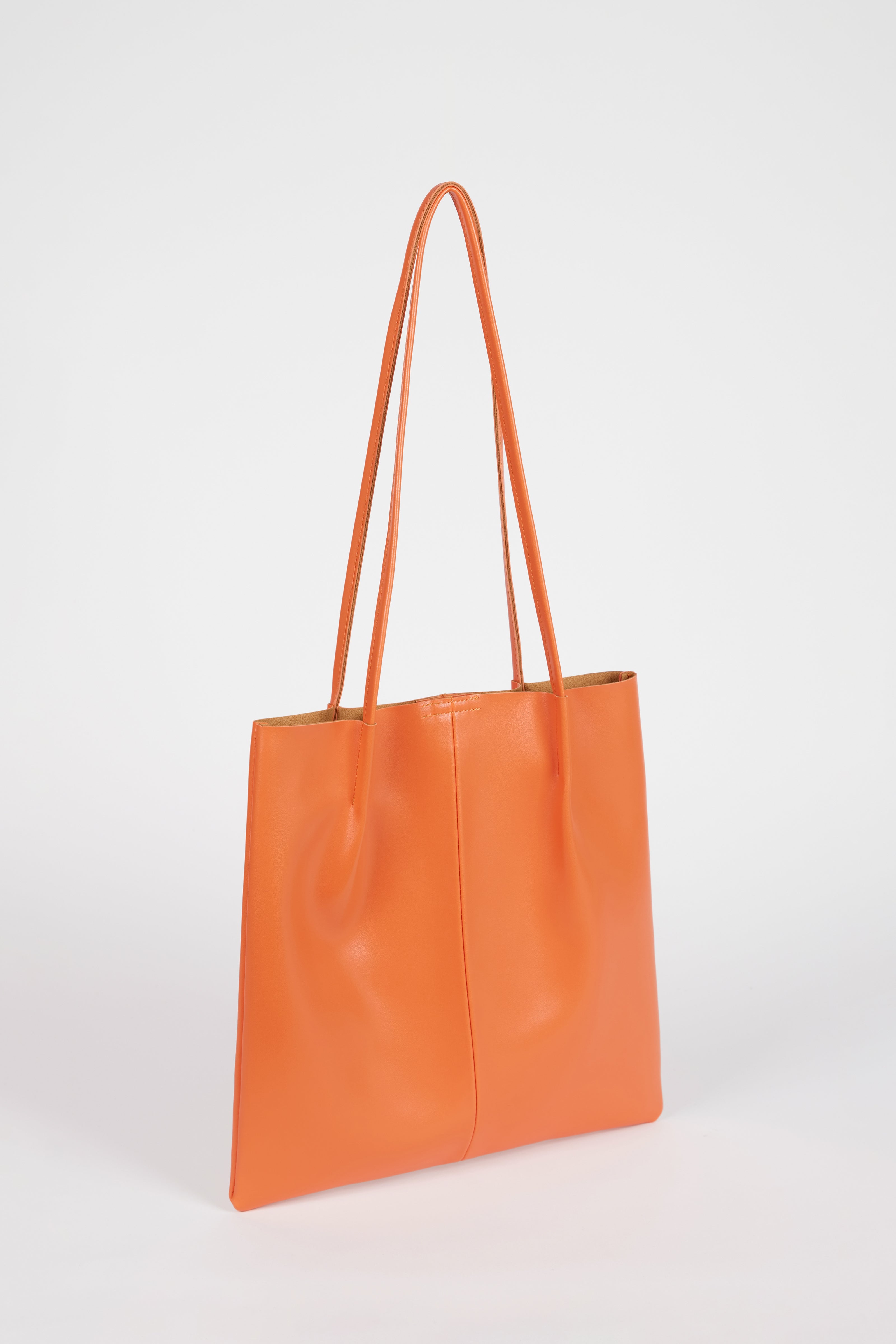 Orange vegan leather pinched strap tote bag