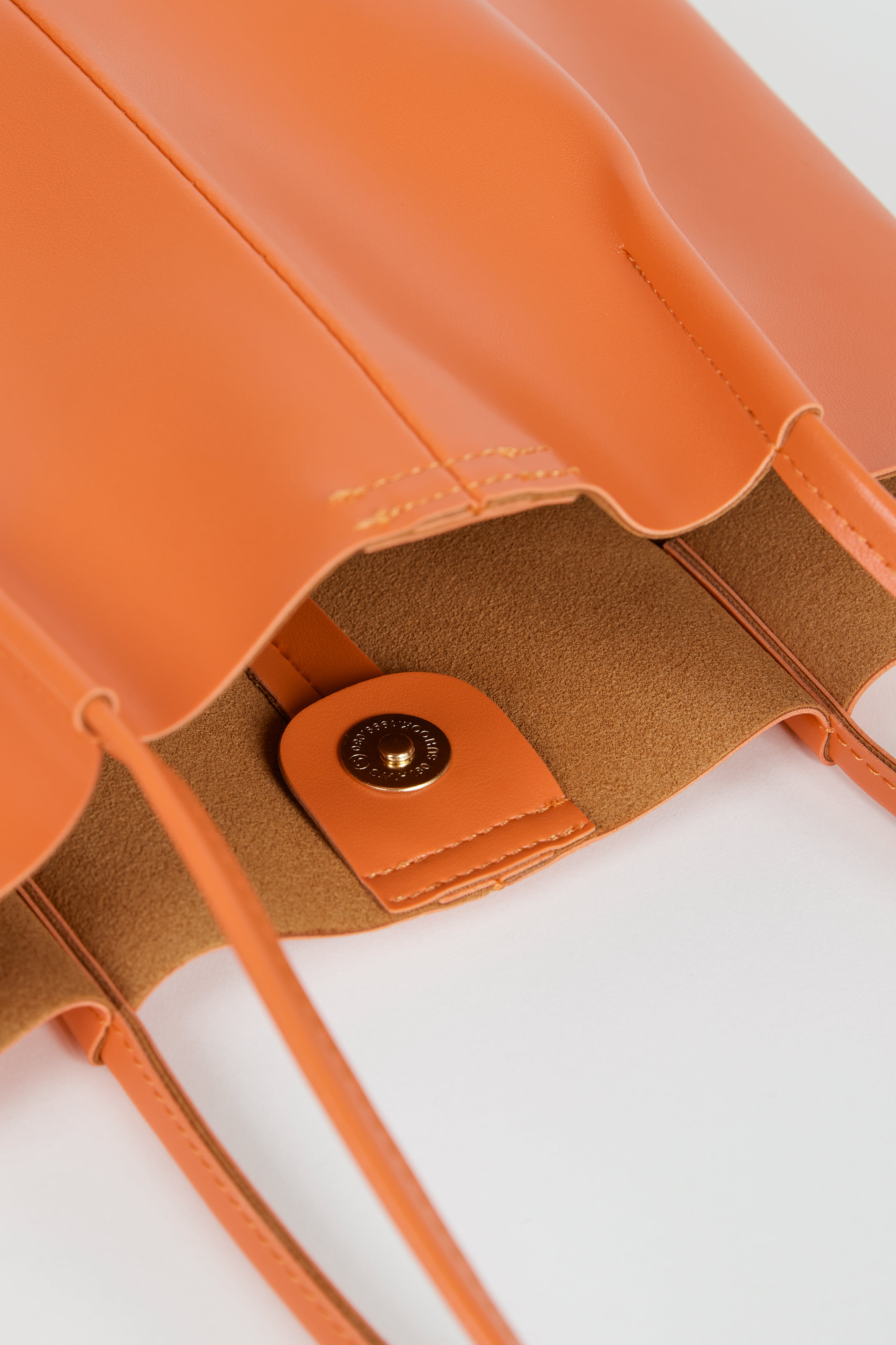 Orange vegan leather pinched strap tote bag